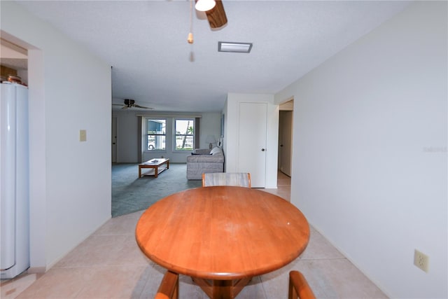 dining room featuring ceiling fan, light tile patterned floors, and a textured ceiling