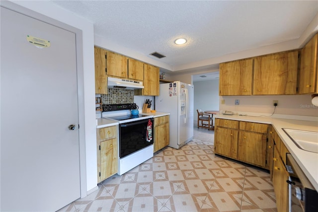 kitchen with backsplash, sink, white appliances, and a textured ceiling