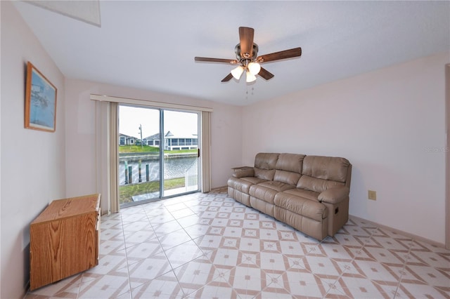 living room with ceiling fan and a water view