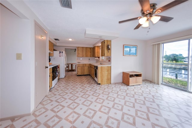 kitchen with stove, white refrigerator, sink, ceiling fan, and dishwashing machine