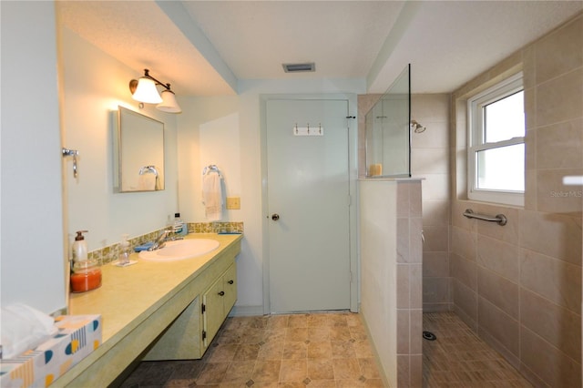 bathroom featuring vanity and tiled shower