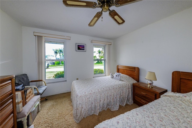 carpeted bedroom with ceiling fan and multiple windows