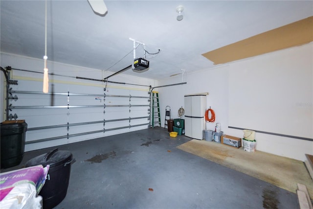 garage with a garage door opener and white refrigerator