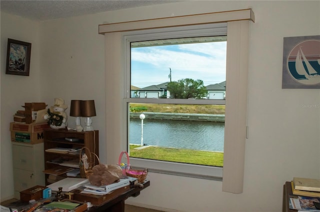 entryway featuring a water view and a textured ceiling