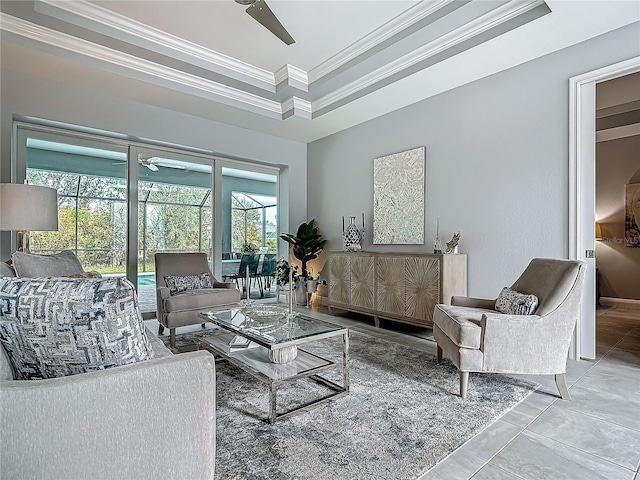 living room with a tray ceiling, tile patterned floors, a high ceiling, and ornamental molding