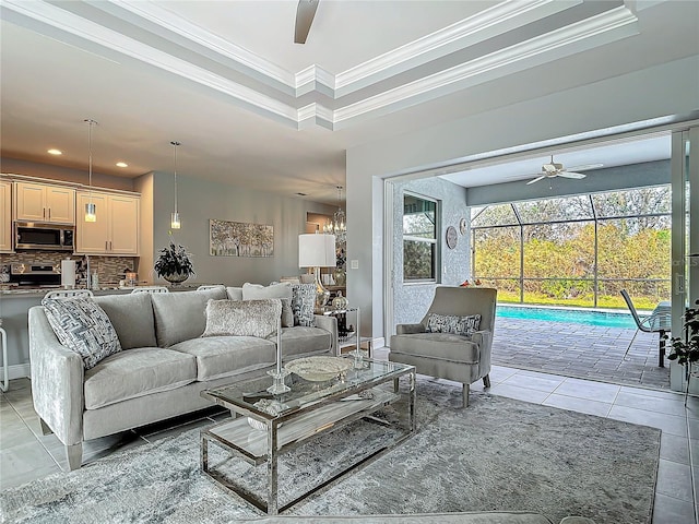 tiled living room featuring a tray ceiling, crown molding, and ceiling fan