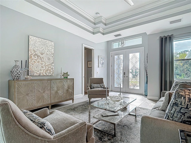 interior space featuring a tray ceiling, a wealth of natural light, french doors, and ornamental molding