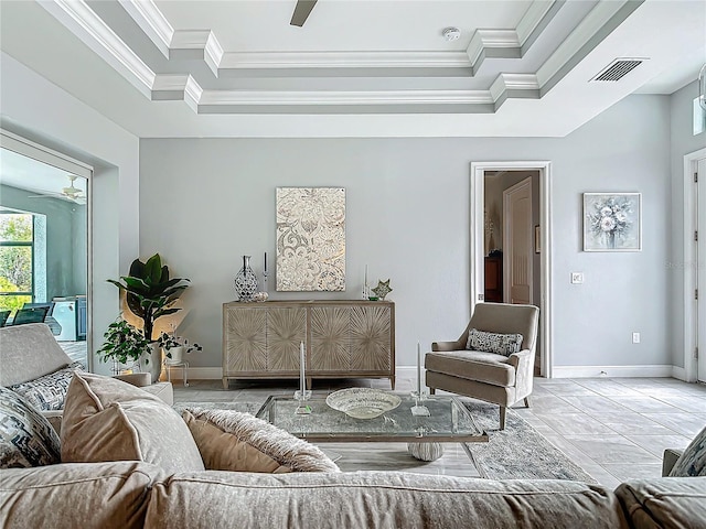 living room featuring ceiling fan, ornamental molding, and a tray ceiling