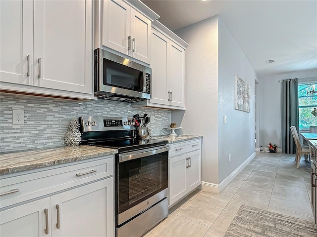 kitchen featuring white cabinets, light stone countertops, and stainless steel appliances