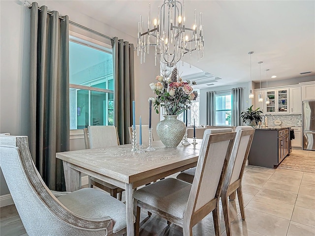 tiled dining space with a chandelier