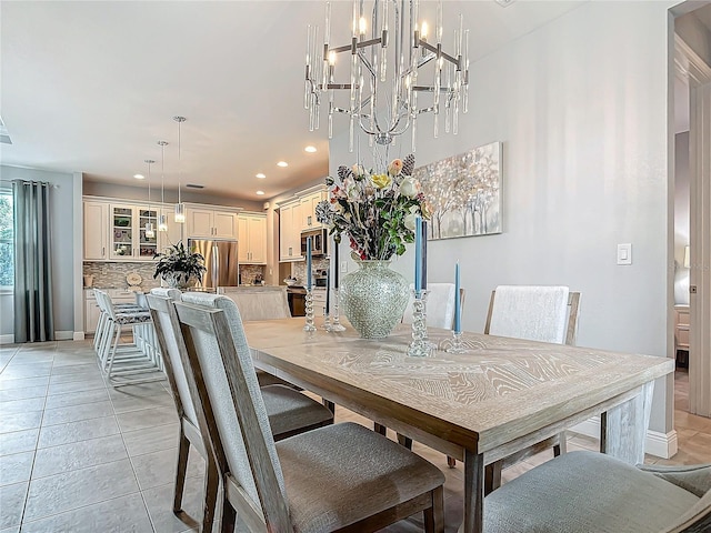 dining area with light tile patterned flooring and an inviting chandelier