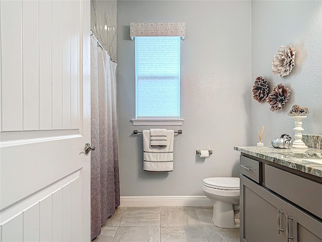 bathroom featuring tile patterned flooring, vanity, and toilet