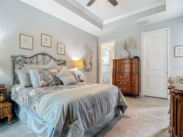 tiled bedroom with ceiling fan, ornamental molding, connected bathroom, and a tray ceiling