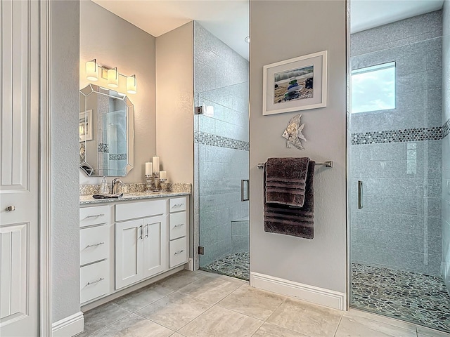 bathroom with tile patterned floors, a shower with door, and vanity