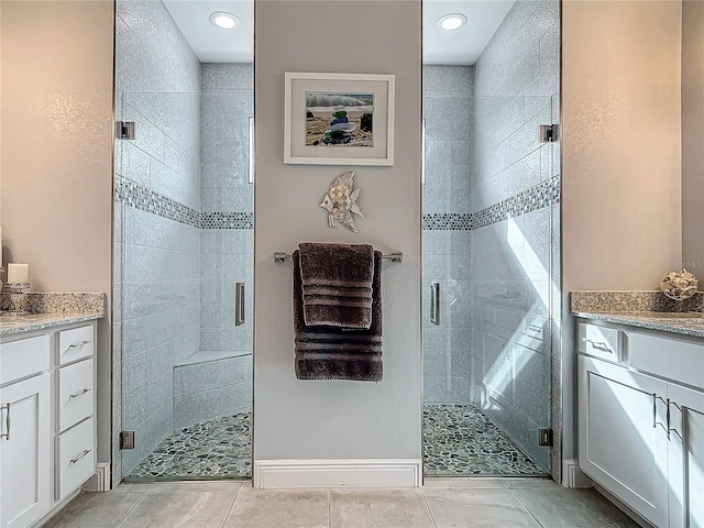 bathroom with tile patterned floors, vanity, and walk in shower