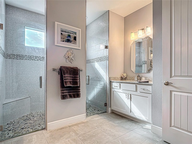 bathroom with tile patterned flooring, vanity, and a shower with door