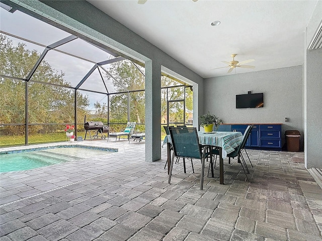 view of patio with glass enclosure, ceiling fan, and area for grilling