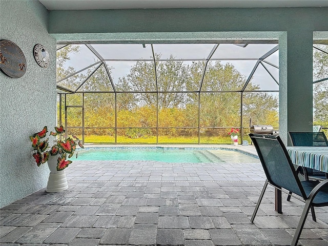 view of pool with a patio area and glass enclosure