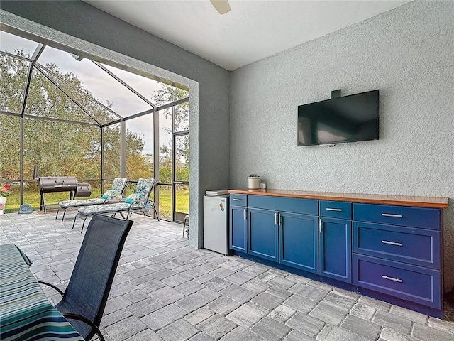 view of patio / terrace featuring glass enclosure and area for grilling