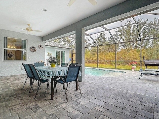 view of patio with ceiling fan and glass enclosure