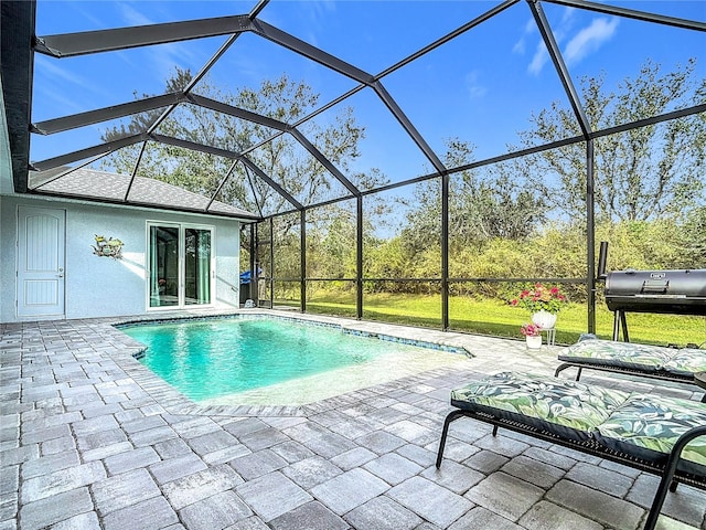 view of swimming pool with glass enclosure and a patio