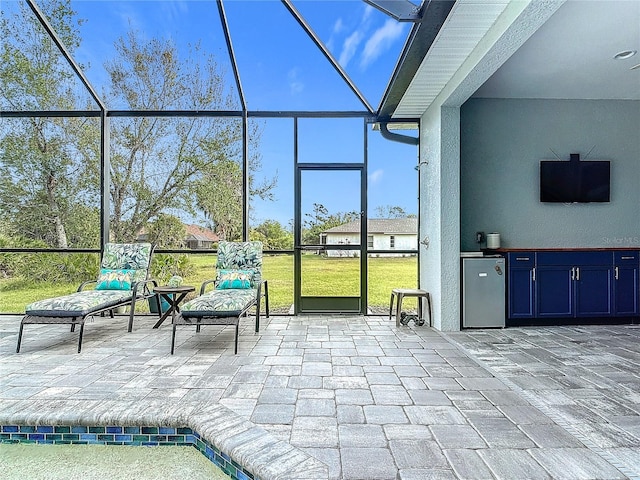 view of patio / terrace featuring an outdoor kitchen and a lanai