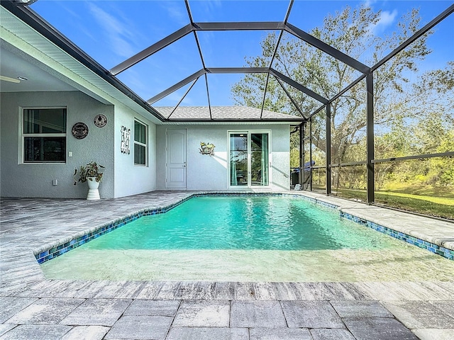 view of swimming pool featuring glass enclosure and a patio