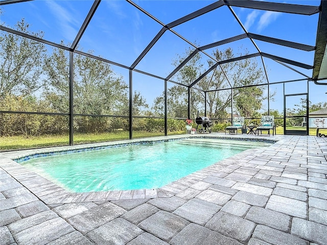 view of pool featuring glass enclosure and a patio area