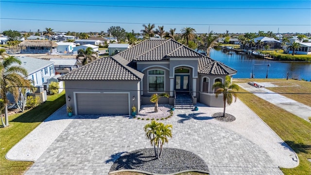 mediterranean / spanish-style house with a water view and a garage