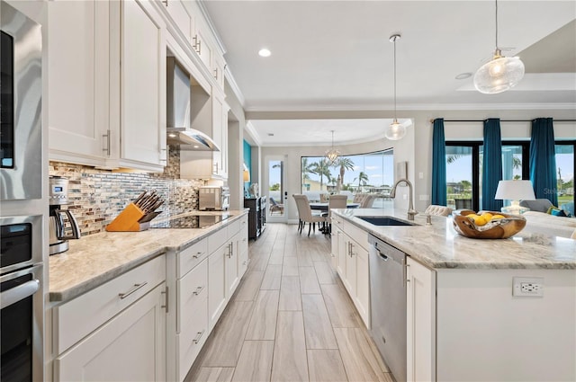 kitchen with a center island with sink, white cabinets, sink, hanging light fixtures, and stainless steel dishwasher