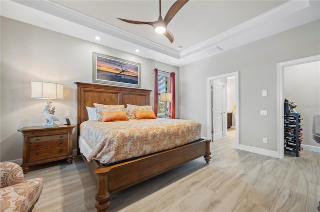 bedroom featuring a tray ceiling, ceiling fan, ornamental molding, and light hardwood / wood-style floors