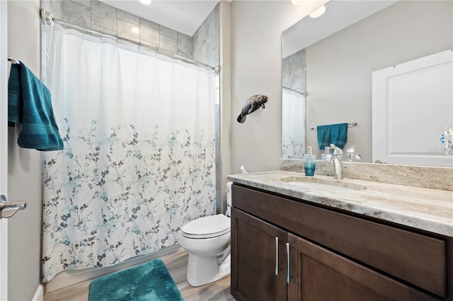 bathroom with walk in shower, hardwood / wood-style floors, vanity, and toilet