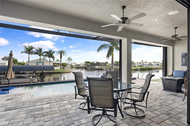 view of patio / terrace featuring ceiling fan and a water view