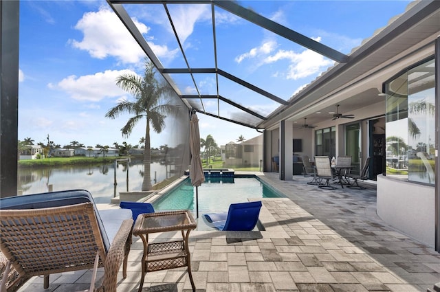 view of swimming pool with a lanai, ceiling fan, a patio area, and a water view