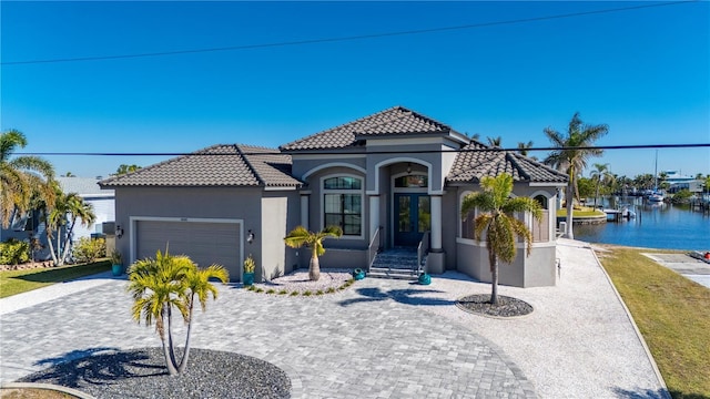 mediterranean / spanish-style home featuring a water view and a garage