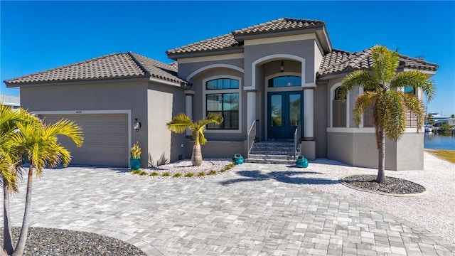 mediterranean / spanish-style home with french doors and a garage