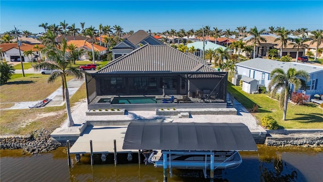 back of property featuring a lanai, a yard, a patio, and a water view