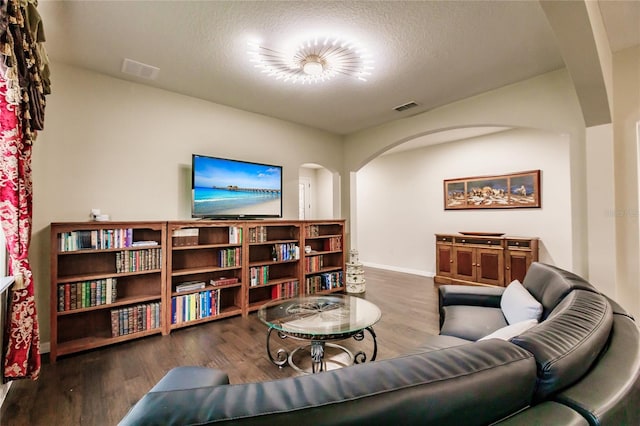 living room featuring dark hardwood / wood-style flooring and a textured ceiling