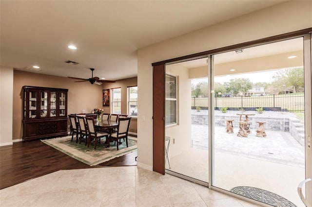 doorway with ceiling fan and tile patterned flooring