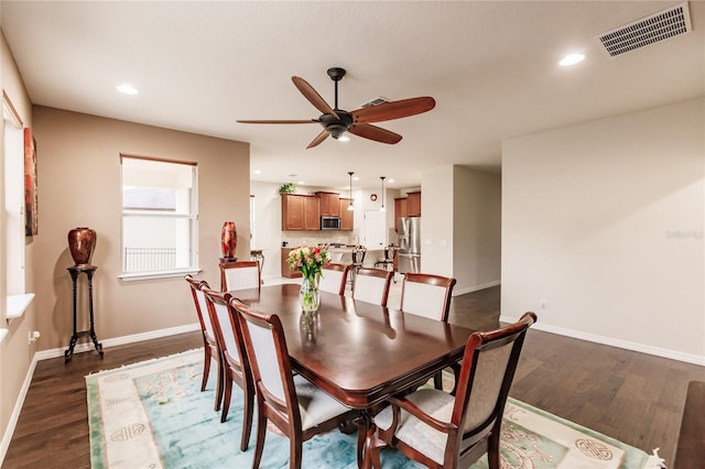 dining room featuring ceiling fan and dark wood-type flooring