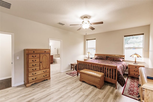 bedroom with ceiling fan, light wood-type flooring, and connected bathroom