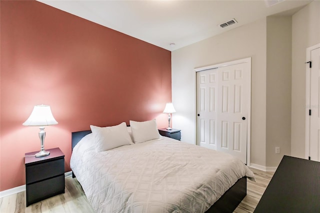 bedroom with a closet and light hardwood / wood-style floors