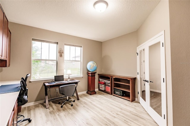 office featuring plenty of natural light, light hardwood / wood-style flooring, and french doors