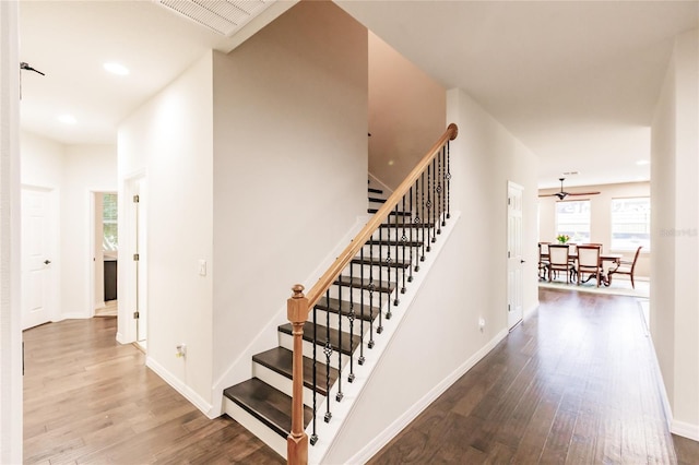 stairs featuring hardwood / wood-style floors and ceiling fan