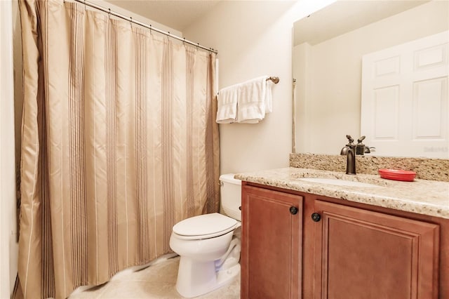 bathroom featuring tile patterned floors, vanity, and toilet