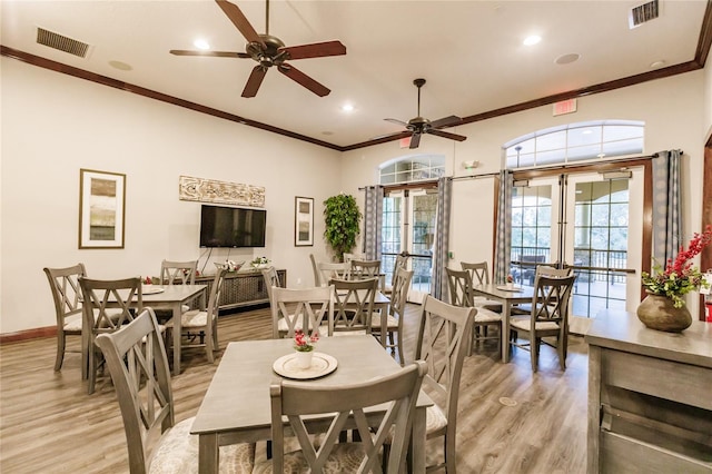 dining room with ceiling fan, french doors, ornamental molding, and light wood-type flooring