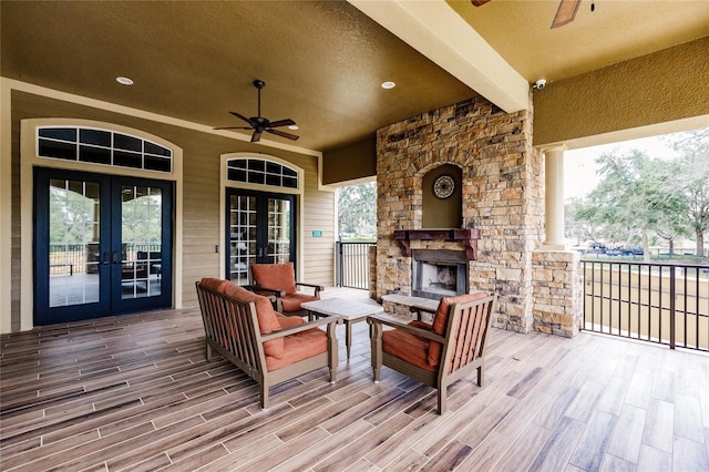 wooden terrace featuring an outdoor living space with a fireplace, ceiling fan, and french doors