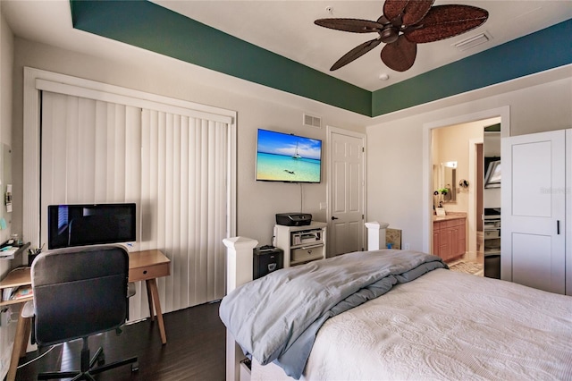 bedroom featuring ensuite bath, dark hardwood / wood-style floors, and ceiling fan