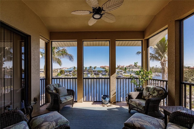 sunroom featuring a water view, ceiling fan, and a wealth of natural light