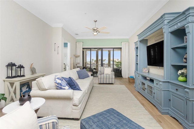 living room with crown molding, light hardwood / wood-style flooring, and ceiling fan